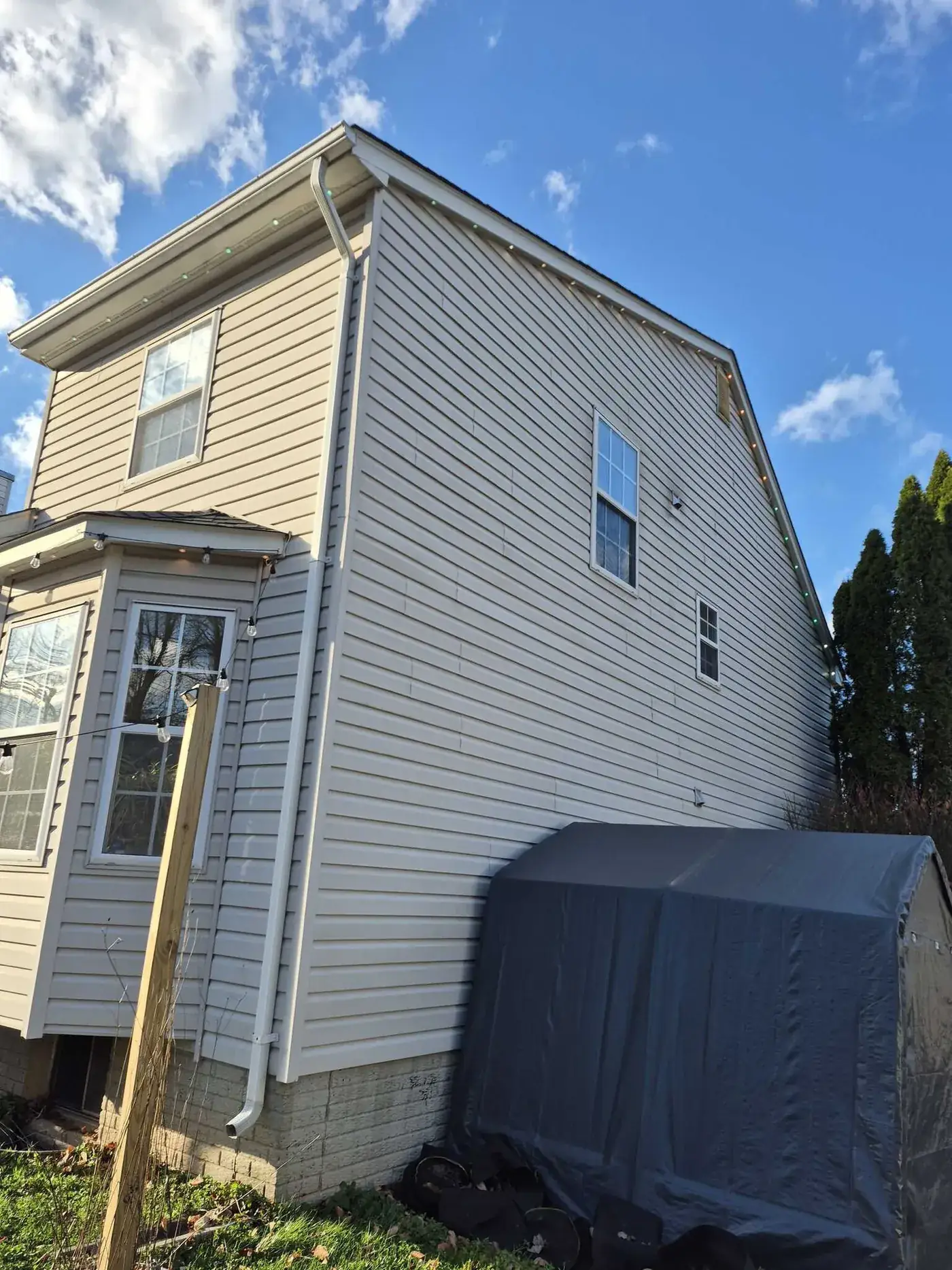 Side elevation of a home showing gutter, downspout and lighting detail along the eaves.